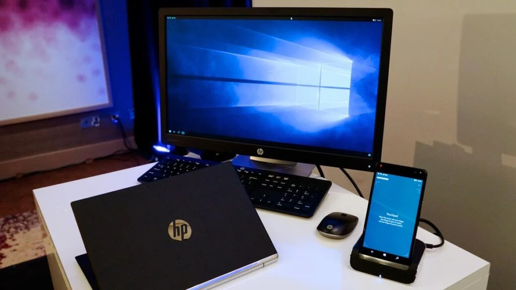 Laptop modern dengan desain tipis sedang digunakan untuk bekerja di meja minimalis dengan pencahayaan alami.